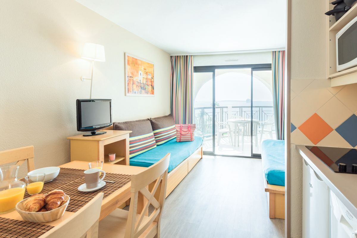 Living area with equipped kitchenette and dining corner opening onto the sea-view balcony — Studio Sea View for 4 guests Cannes