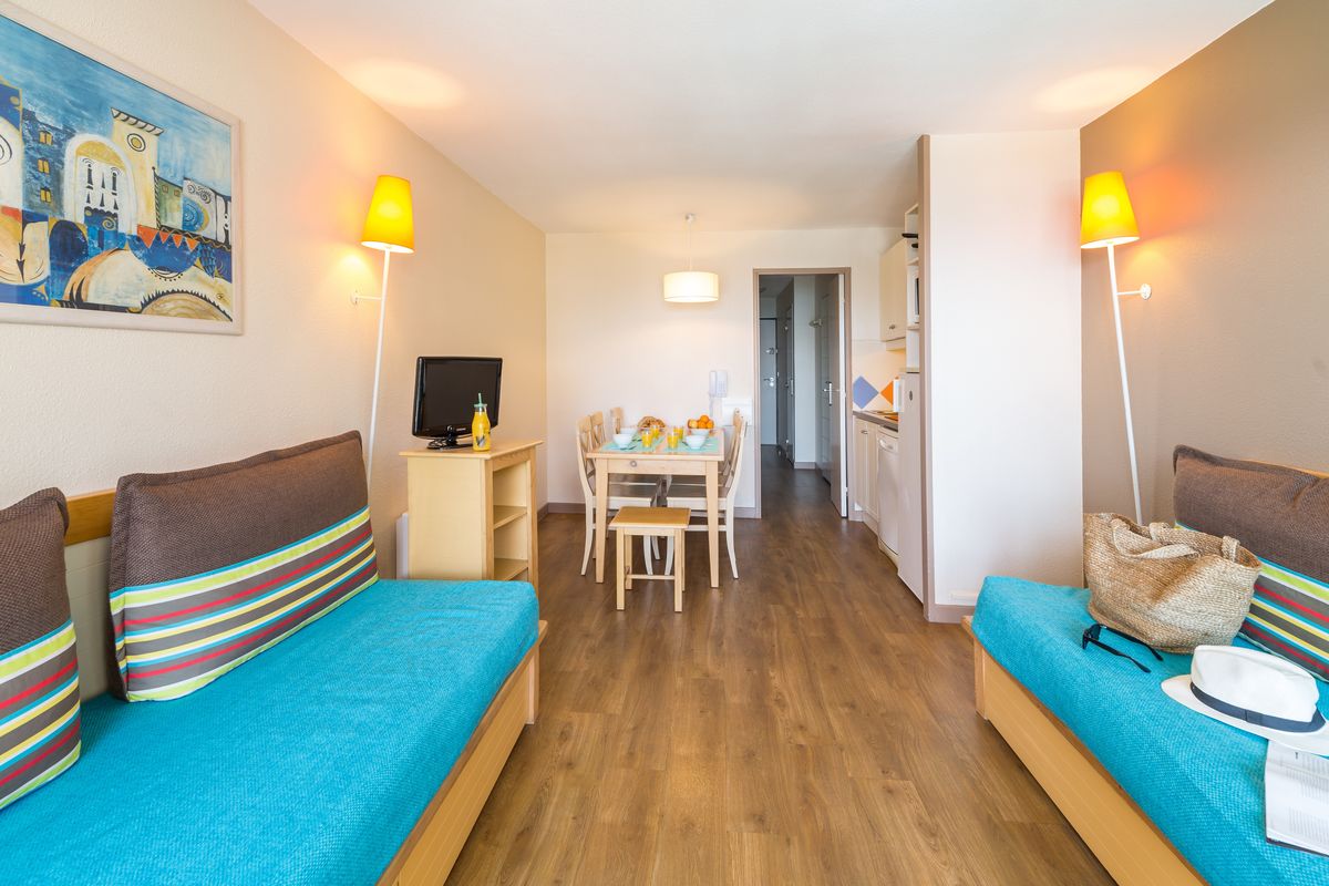 Salon avec 2 canapés-lits, coin repas et balcon vue mer — Appartement 2 Chambres Cannes