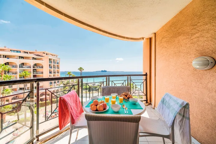 Petit-déjeuner dressé sur le balcon vue mer d'un appartement une chambre avant une journée de rendez-vous ILTM