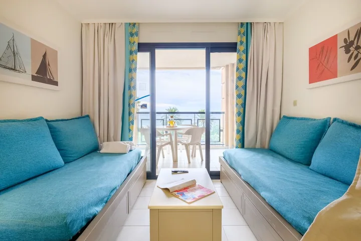 Salon avec banquettes et vue mer dans un appartement une chambre, un endroit calme pour préparer ses rendez-vous ILTM