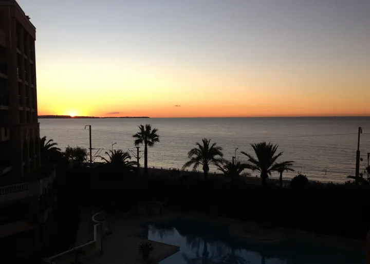 Sunset over the bay of Cannes and the pool of the residence, where crews come back after a day of racing