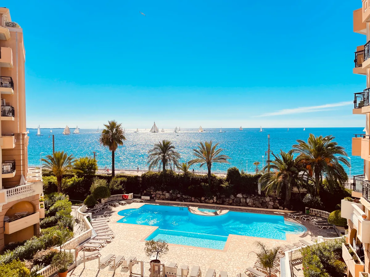 Sailing yachts racing in the bay of Cannes seen from the pool of Résidence La Palme d'Azur in Cannes La Bocca during the Régates Royales